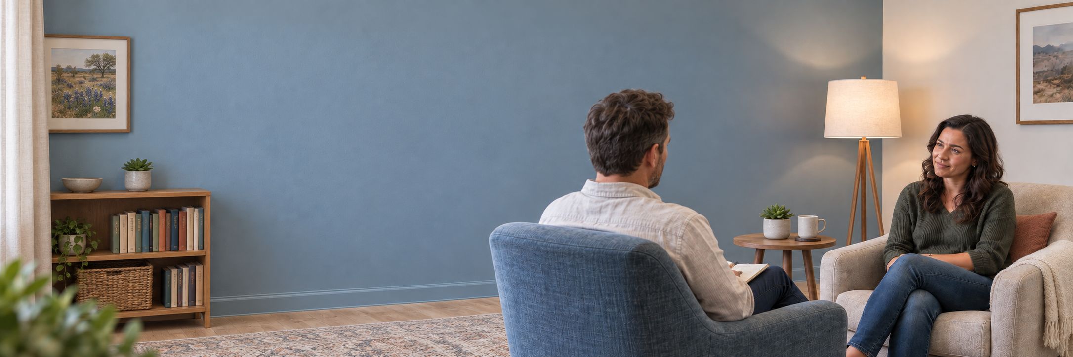 A therapist and client talking in a calm, softly lit counseling room