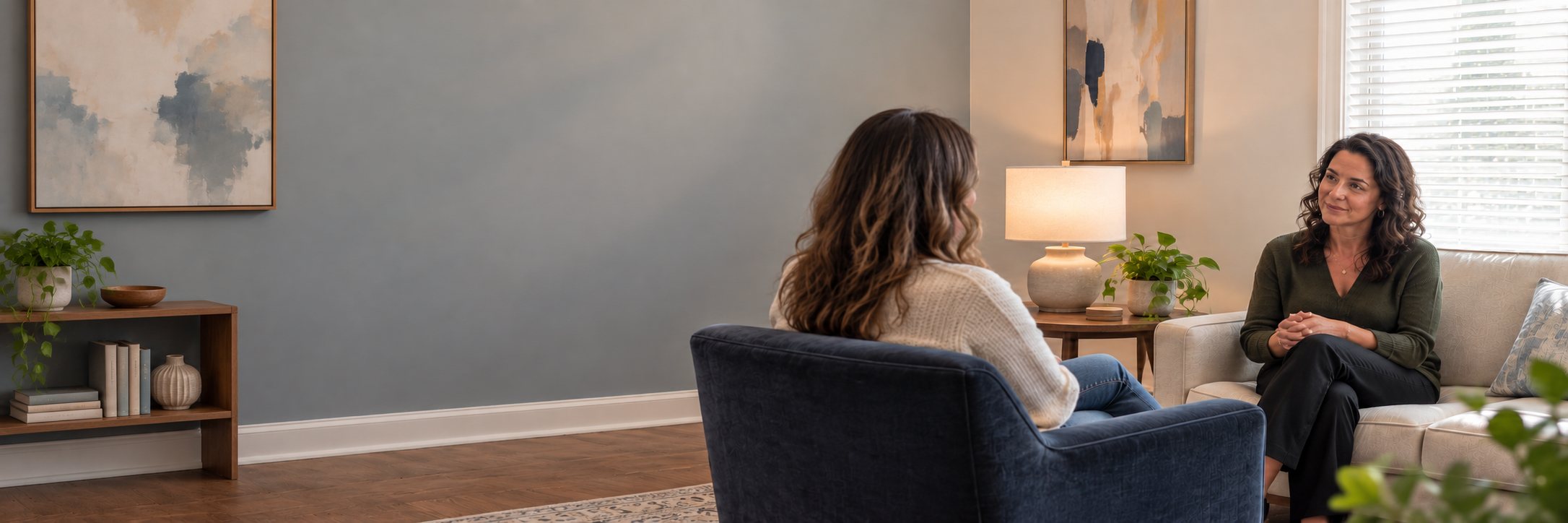 A therapist and client talking in a calm, softly lit counseling room